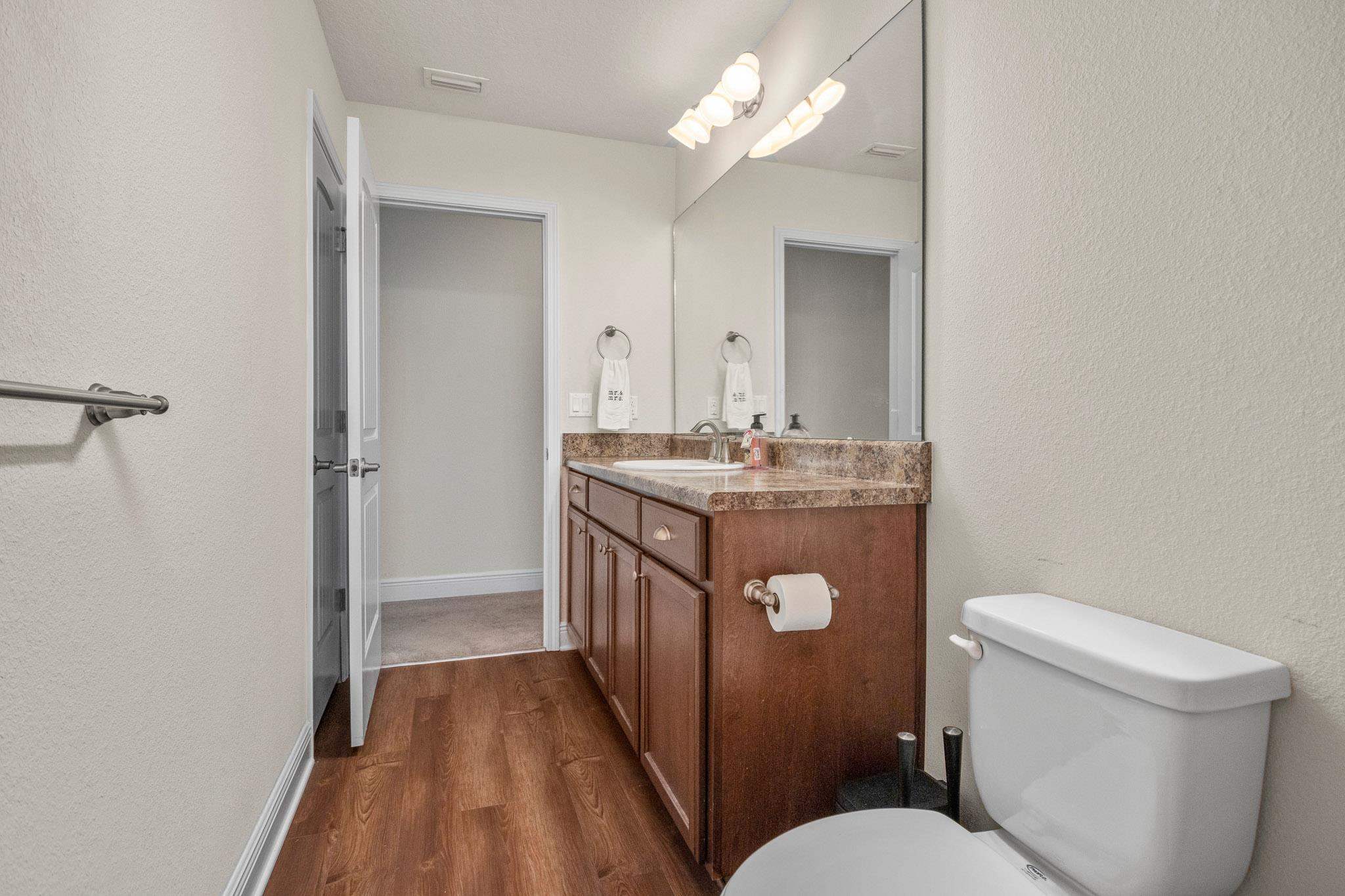 5070 Carmell Ridge Circle Milton, FL 32570 - Photo 17 of 36 a bathroom with a sink a toilet a mirror and vanity