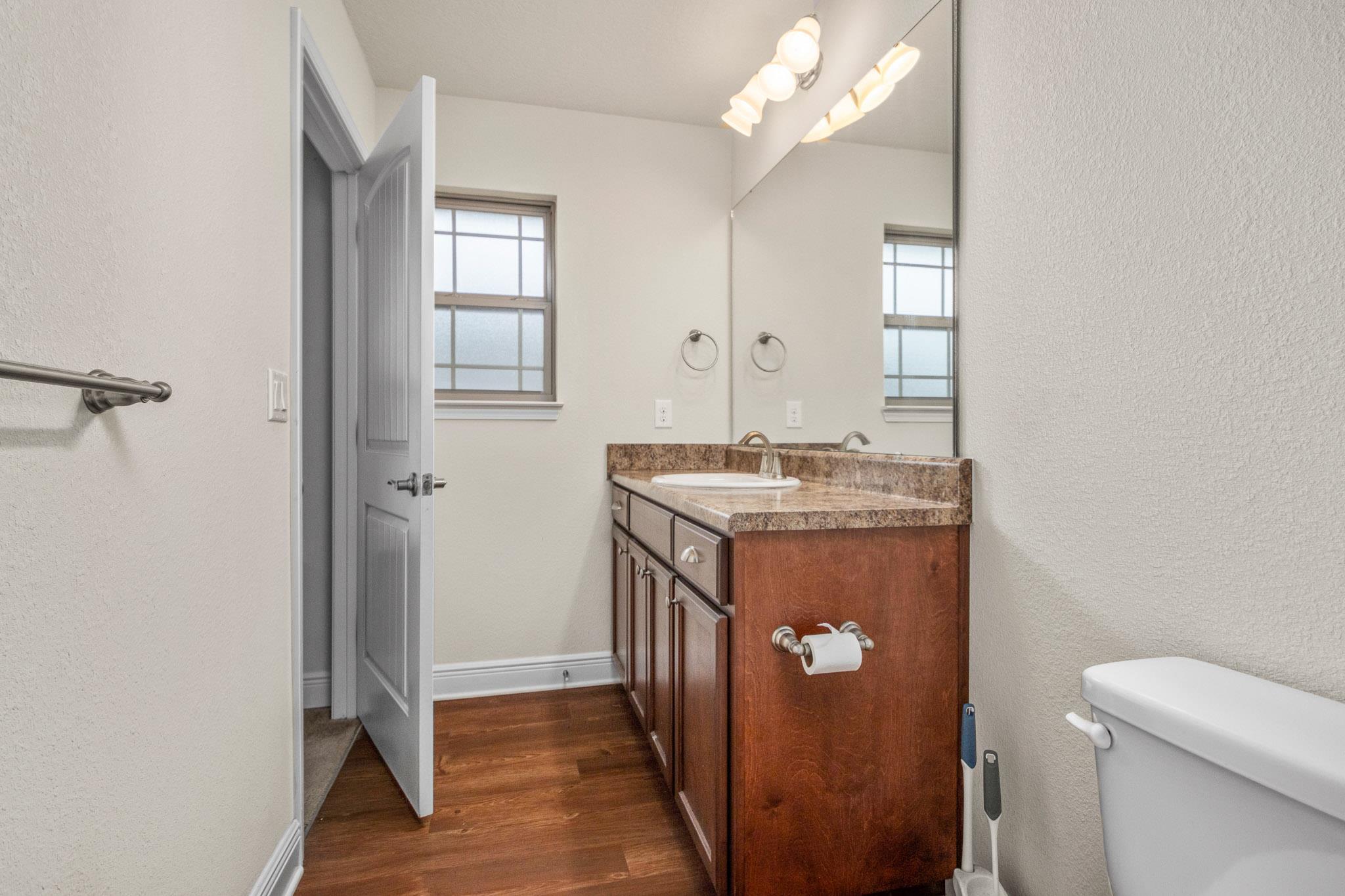 5070 Carmell Ridge Circle Milton, FL 32570 - Photo 29 of 36 a bathroom with a granite countertop sink a toilet and mirror