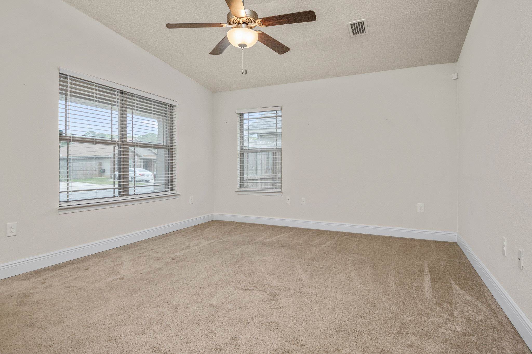 5070 Carmell Ridge Circle Milton, FL 32570 - Photo 4 of 36 an empty room with windows and fan