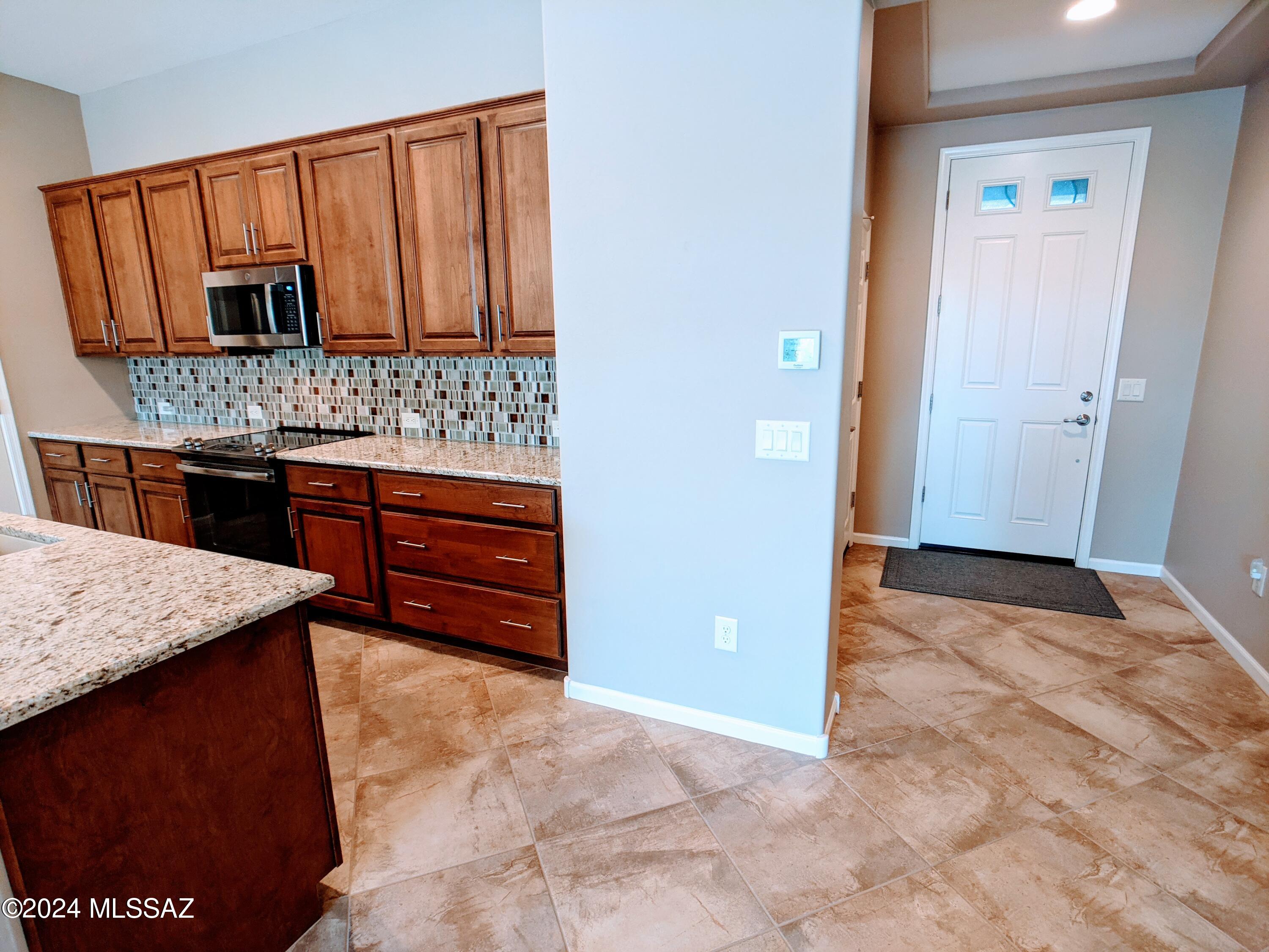 61021 East Slate Road Oracle, AZ 85623 - Photo 7 of 18 a view of kitchen with granite countertop cabinets and refrigerator