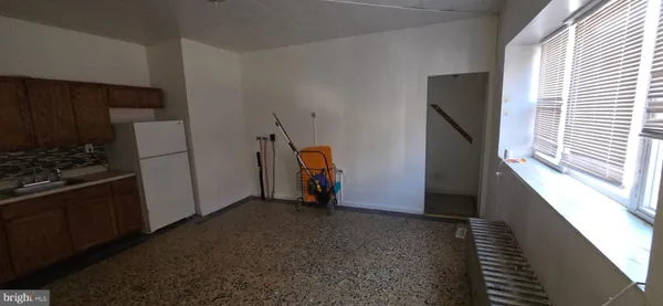 a view of empty room with wooden floor and electronic appliances