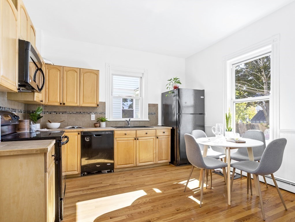 8 Marbury Terrace, Unit 1 Boston, MA 02130 - Photo 6 of 35 a kitchen with a stove a sink refrigerator dining table and chairs