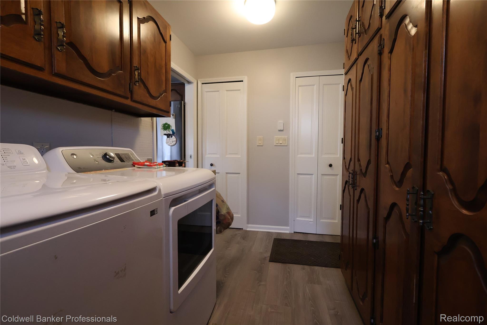 22305 King Road Trenton, MI 48183 - Photo 11 of 26 Washroom featuring dark wood finished floors, washer and dryer, and cabinet space (just off the kitchen)