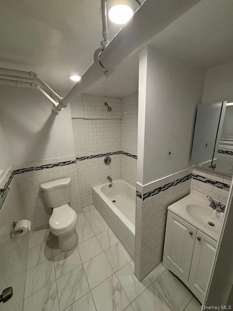 28 West Neck Road, Unit 14 Huntington, NY 11743 - Photo 13 of 13 Full bathroom with wainscoting, tile walls, vanity, and bathtub / shower combination