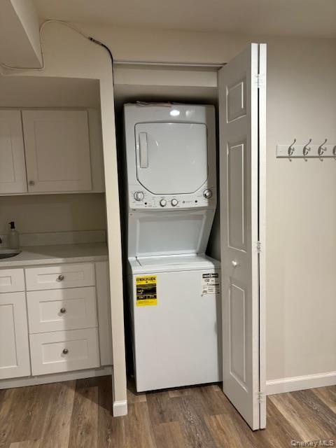 28 West Neck Road, Unit 14 Huntington, NY 11743 - Photo 9 of 13 Laundry area featuring dark wood-style flooring and stacked washer / drying machine