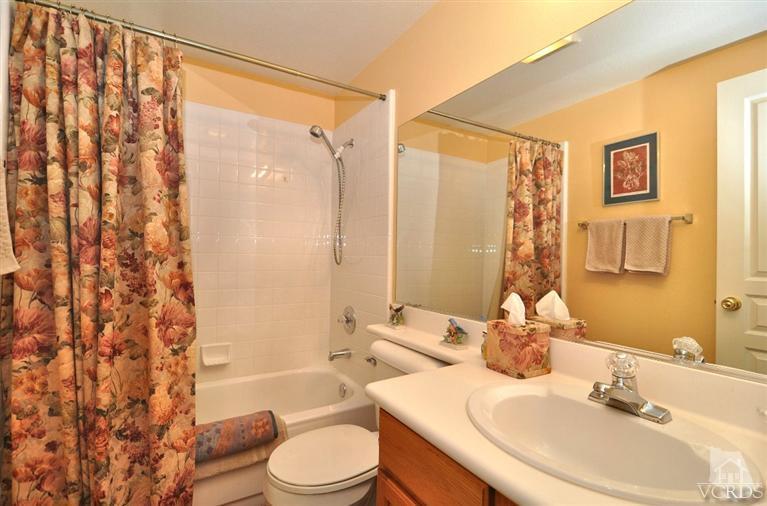 394 Woodland Road Simi Valley, CA 93065 - Photo 14 of 26 a bathroom with a sink a toilet and shower curtain