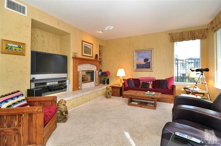 394 Woodland Road Simi Valley, CA 93065 - Photo 8 of 26 a living room with furniture a flat screen tv and a fireplace