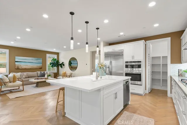 a large kitchen with stainless steel appliances kitchen island a large counter top a sink a stove and a refrigerator