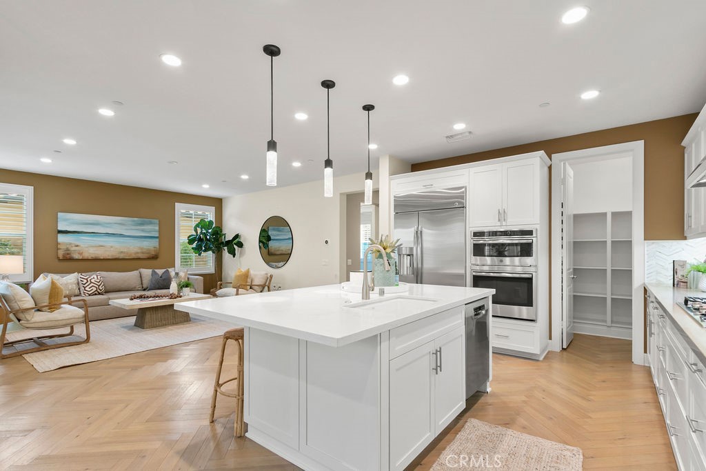 8 Platal Street Rancho Mission Viejo, CA 92694 - Photo 11 of 40 a large kitchen with stainless steel appliances kitchen island a large counter top a sink a stove and a refrigerator