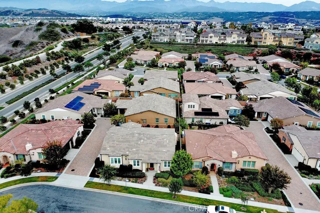 an aerial view of residential houses with outdoor space and parking