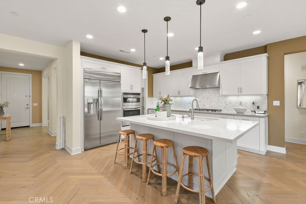 8 Platal Street Rancho Mission Viejo, CA 92694 - Photo 3 of 40 a kitchen with kitchen island granite countertop a sink a center island and stainless steel appliances