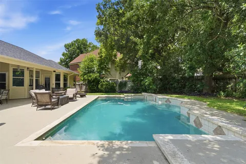a view of a house with swimming pool and sitting area