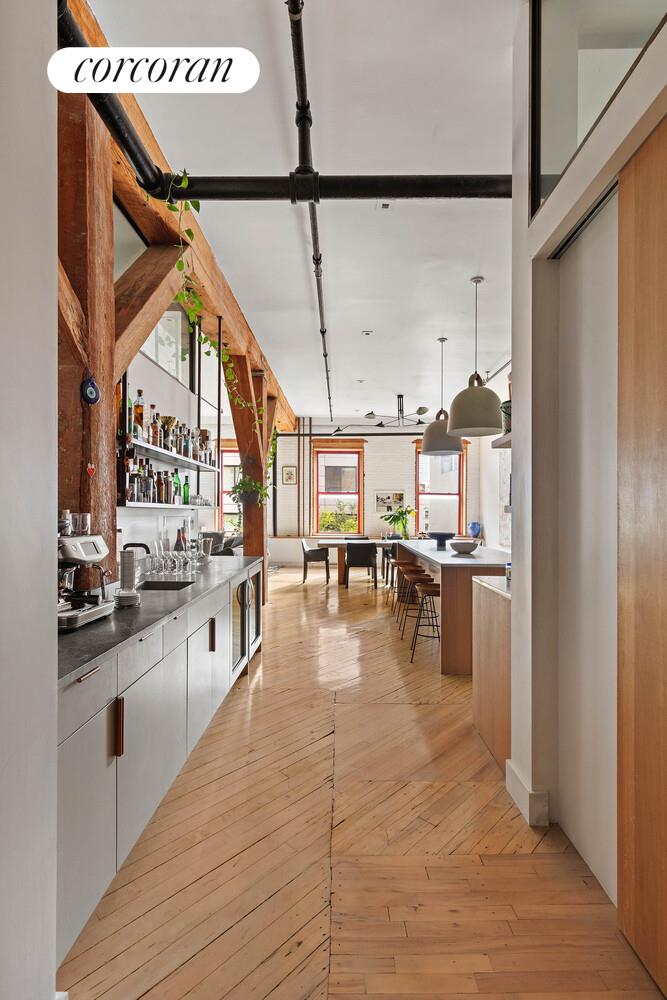85 North 3rd Street, Unit 309 Brooklyn, NY 11249 - Photo 11 of 16 a kitchen with stainless steel appliances granite countertop a refrigerator a oven and white cabinets with wooden floor