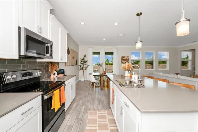 a kitchen with kitchen island granite countertop a sink appliances cabinets and a counter top space