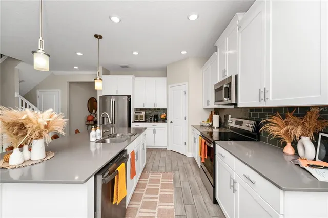 a kitchen with stainless steel appliances kitchen island granite countertop a stove a sink and a refrigerator