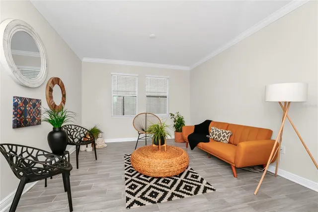 a living room with furniture potted plant and a wooden floor
