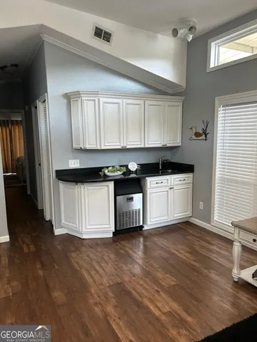 a kitchen with stainless steel appliances granite countertop a stove a sink and white cabinets