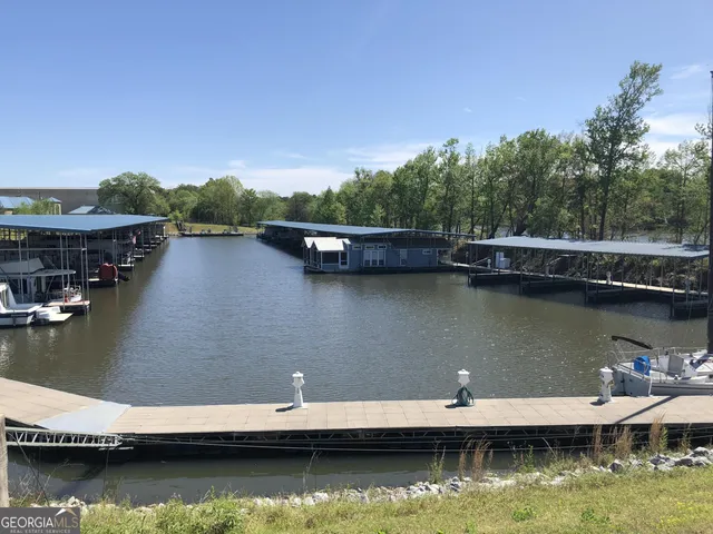 an aerial view of water with boats and trees in the background