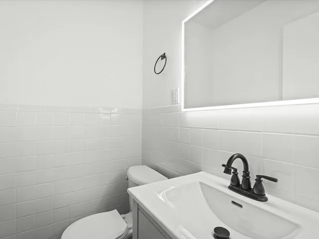 a bathroom with a toilet sink and mirror