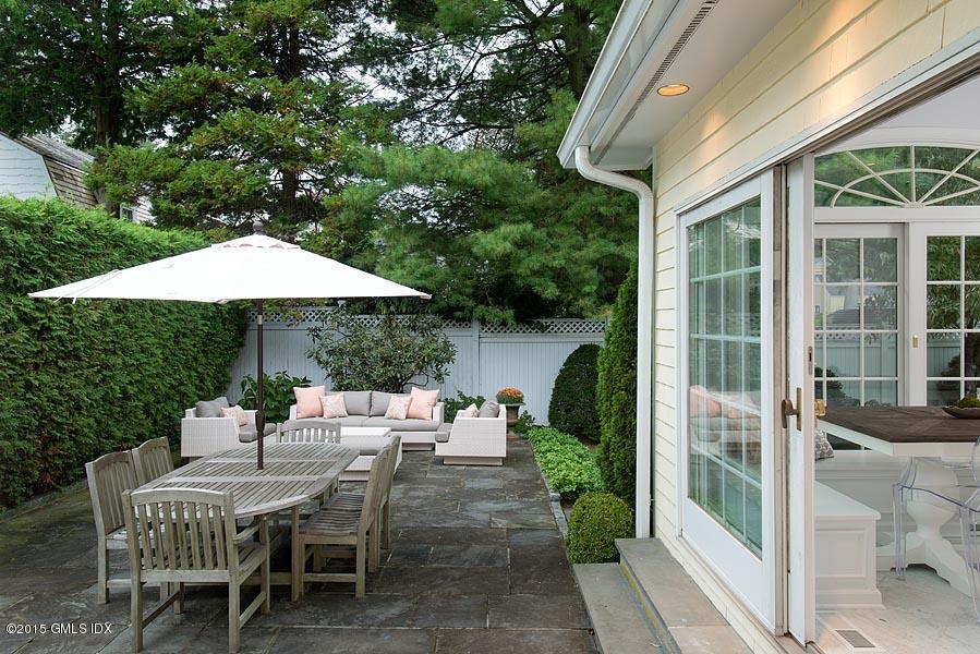 24 Meadow Road Riverside, CT 06878 - Photo 15 of 16 a patio with a table and chairs under an umbrella