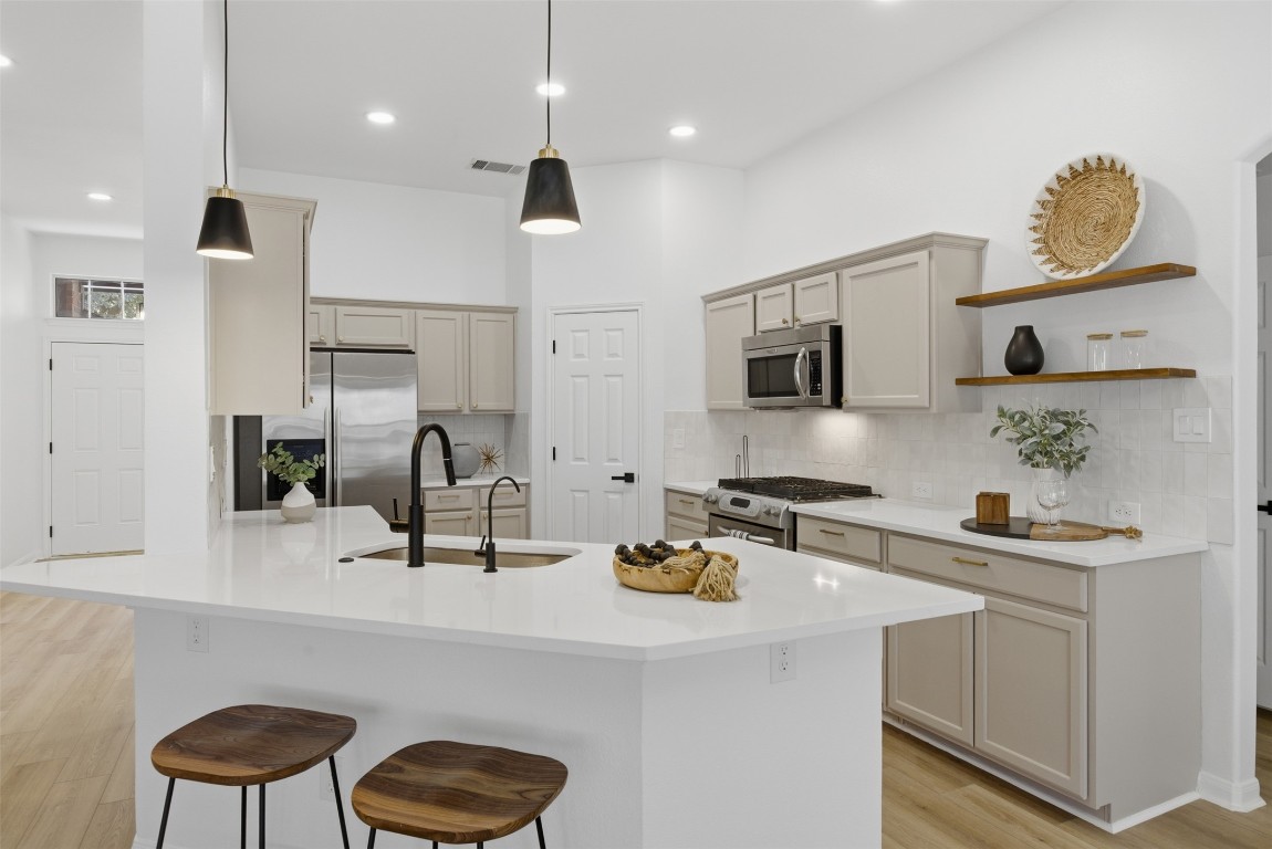 a kitchen with stainless steel appliances a sink a stove and a refrigerator