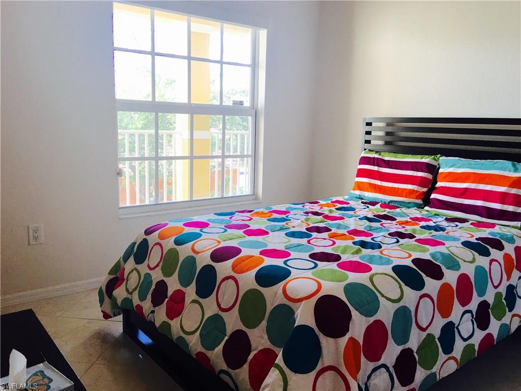 4530 Botanical Pl Circle, Unit 206 Naples, FL 34112 - Photo 5 of 25 a bedroom with a bed and a window