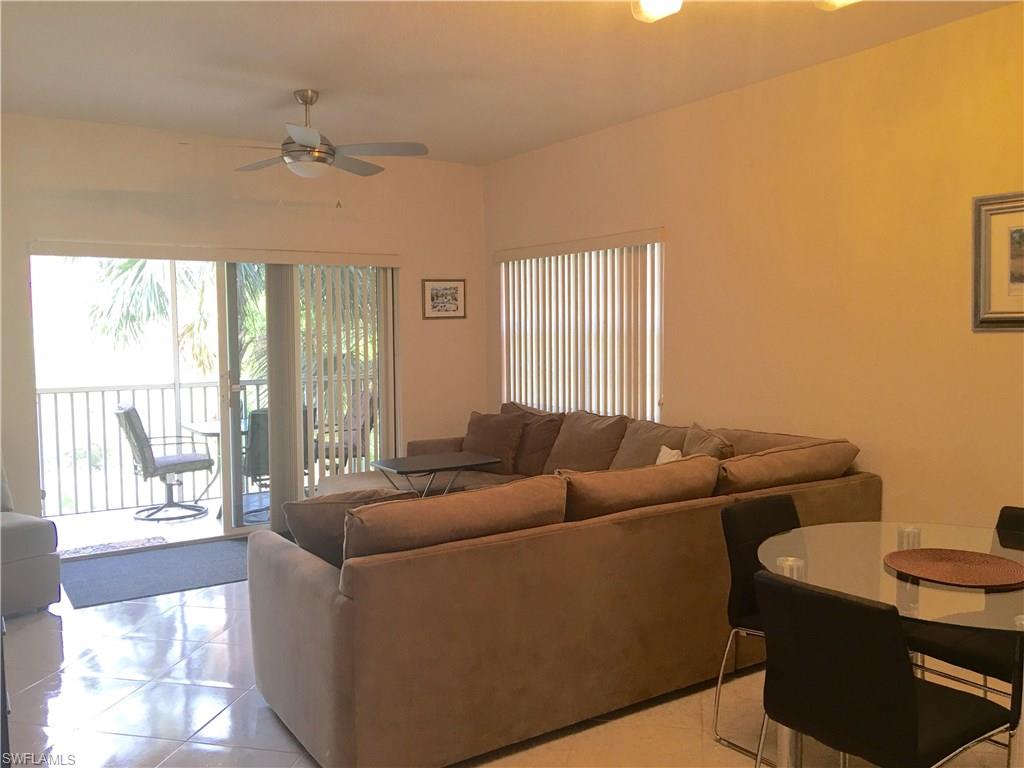 4530 Botanical Pl Circle, Unit 206 Naples, FL 34112 - Photo 8 of 25 a living room with furniture and a large window