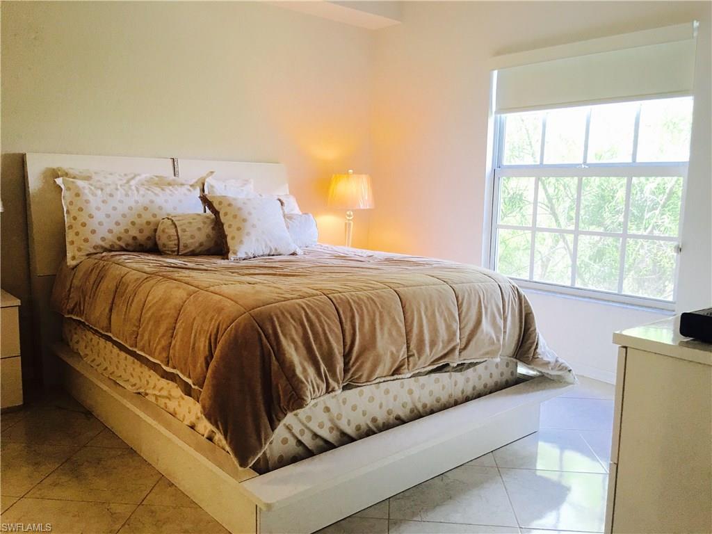 4530 Botanical Pl Circle, Unit 206 Naples, FL 34112 - Photo 10 of 25 a bedroom with a bed and window