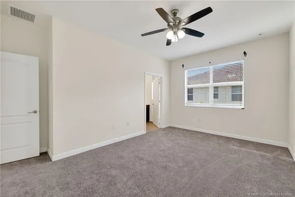 an empty room with fan and windows