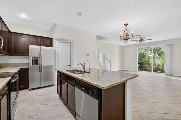 a kitchen with stainless steel appliances granite countertop a sink dishwasher a refrigerator and a stove