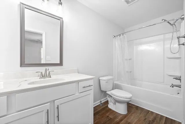 a bathroom with a toilet sink a mirror and shower