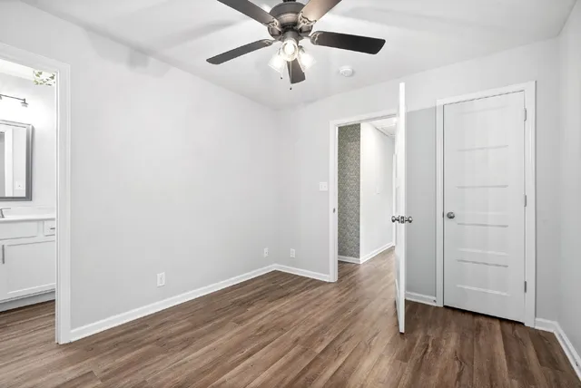 an empty room with wooden floor a ceiling fan and closet