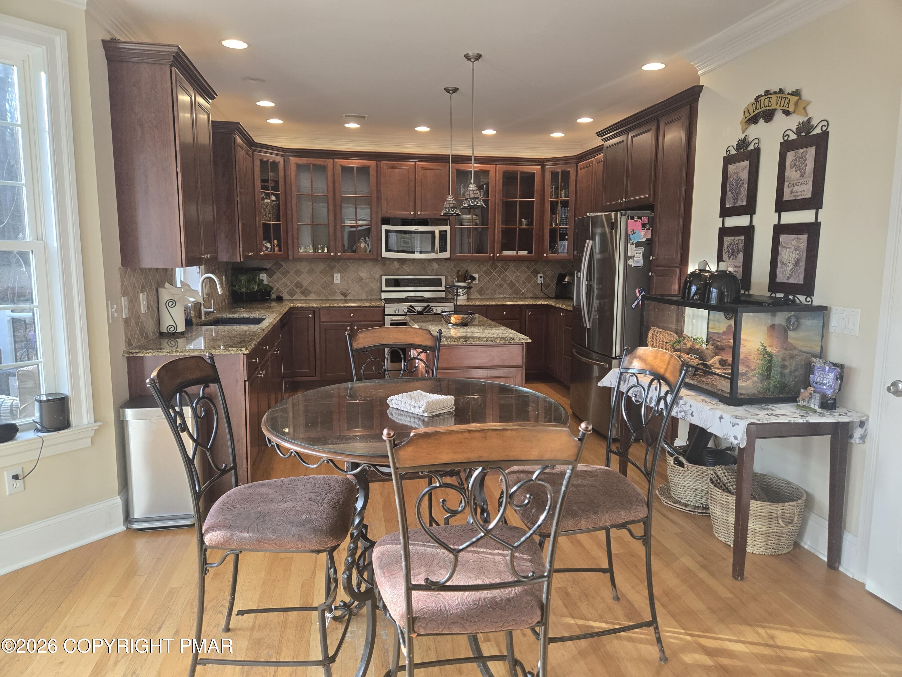 110 Crocus Lane Milford, PA 18337 - Photo 8 of 35 a dining room with stainless steel appliances kitchen island granite countertop a table and chairs
