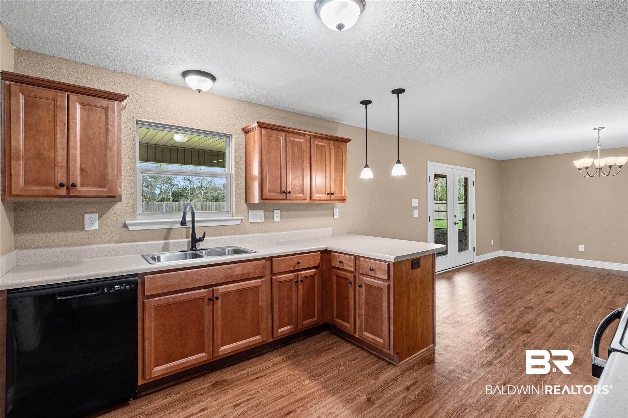 101 Washington Boulevard Foley, AL 36535 - Photo 10 of 32 Kitchen featuring dishwasher, wood finish cabinets, light countertops, french doors, and a peninsula