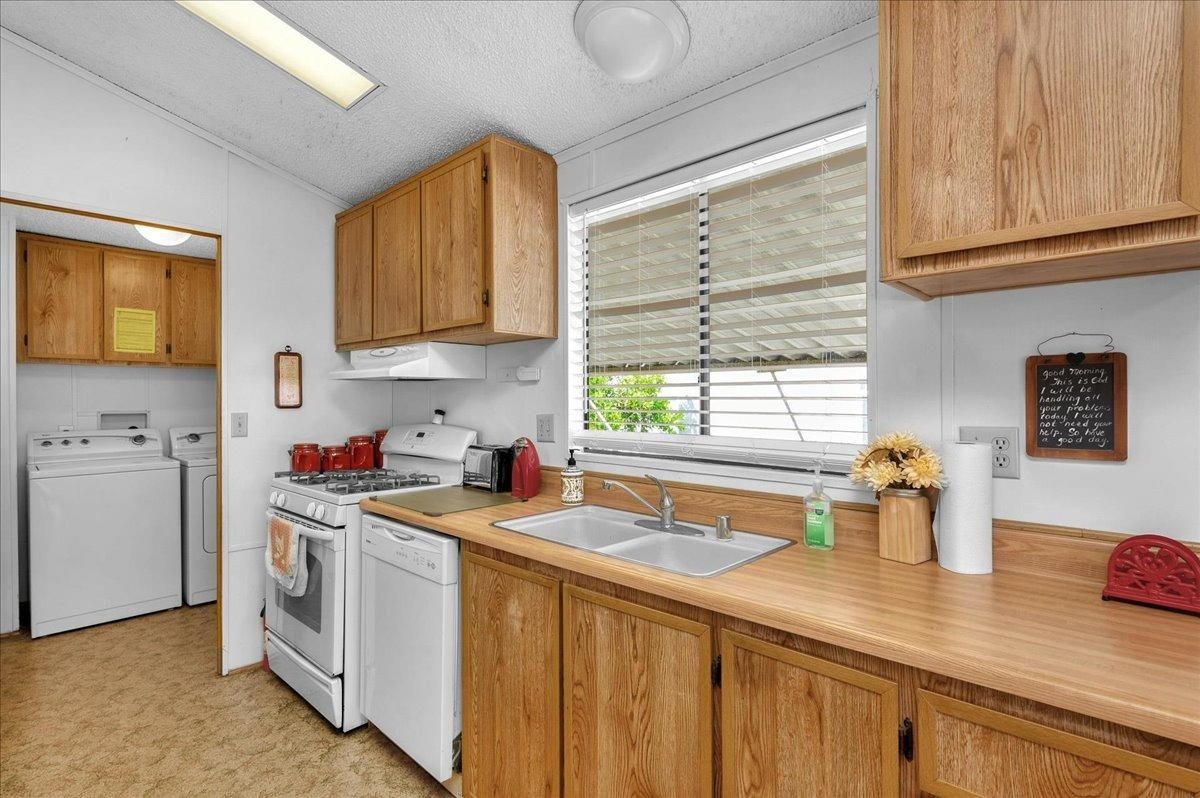 1001 Sylmar Avenue, Unit 199 Clovis, CA 93612 - Photo 7 of 50 a kitchen with stainless steel appliances white cabinets sink and window