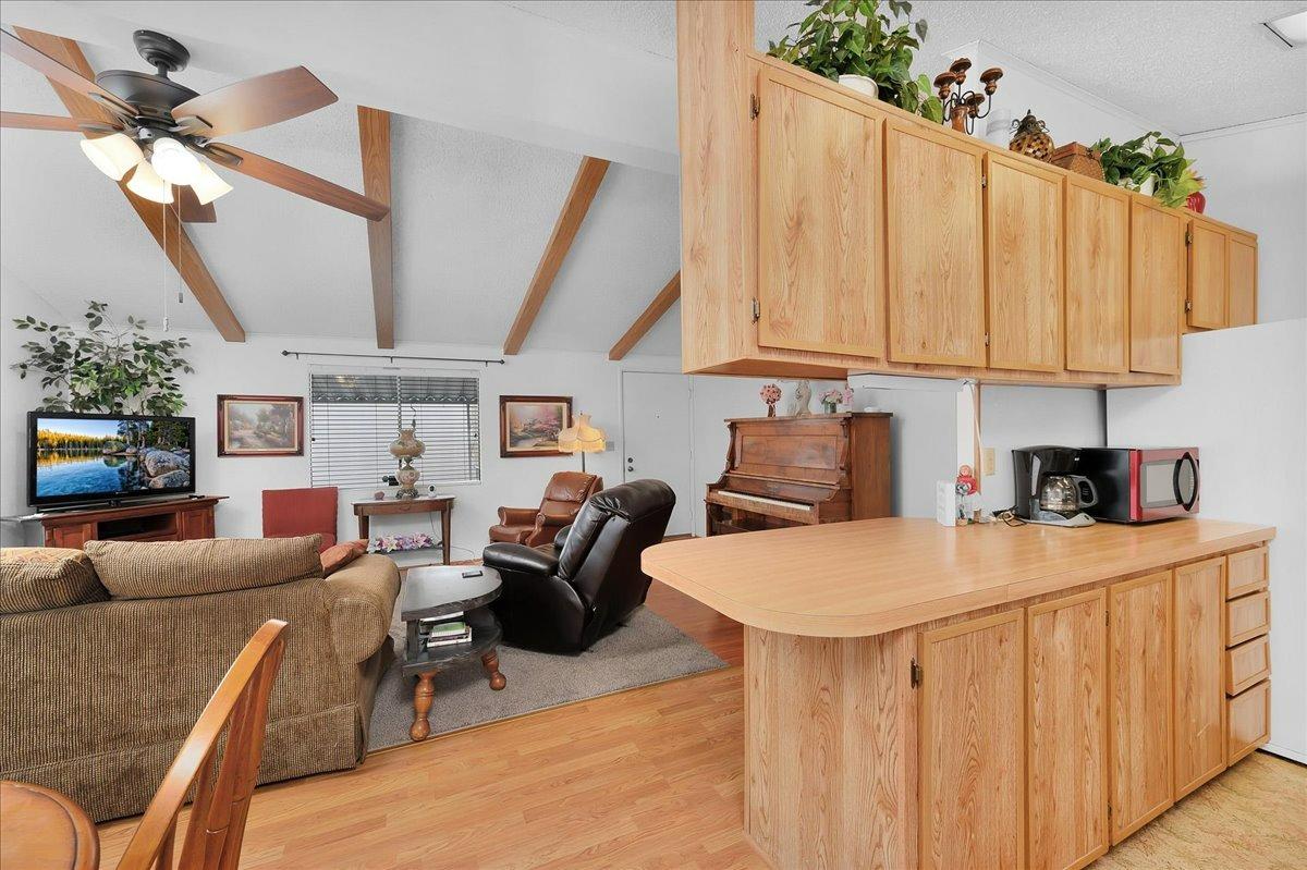 1001 Sylmar Avenue, Unit 199 Clovis, CA 93612 - Photo 9 of 50 a kitchen with stainless steel appliances kitchen island granite countertop a table chairs in it and a wooden floor