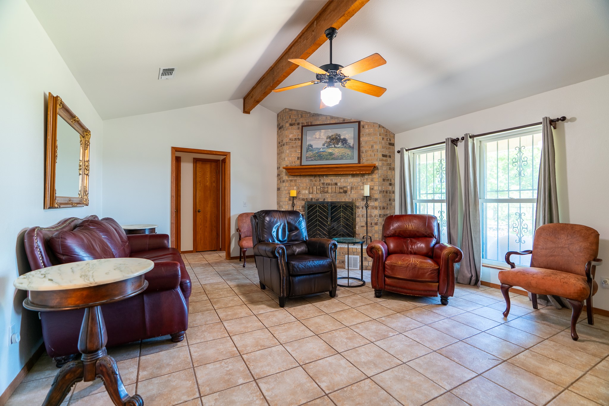 400 619th Spur Elgin, TX 78621 - Photo 23 of 40 A corner brick fireplace anchors this inviting living space with high beamed ceilings.