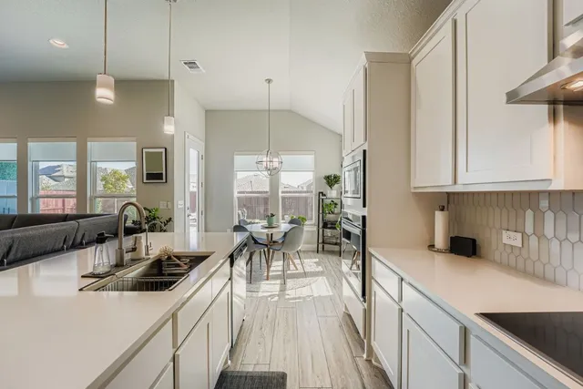 a kitchen with counter top space a sink cabinets and appliances