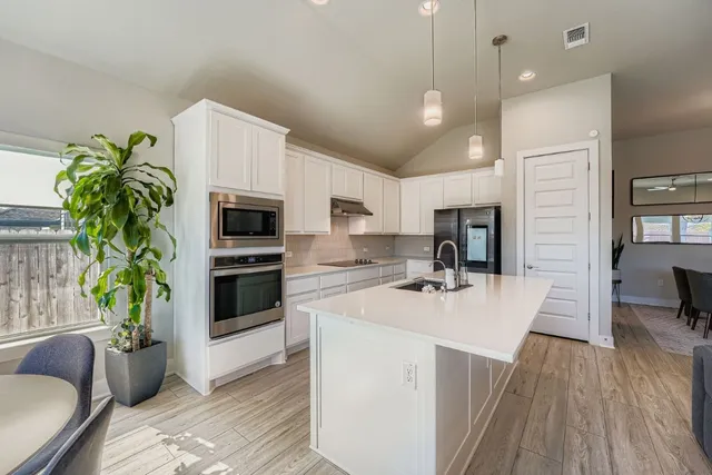 a open kitchen with sink a microwave and refrigerator