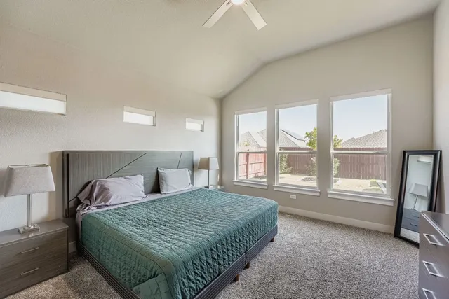 a bedroom with a balcony a bed and a large window