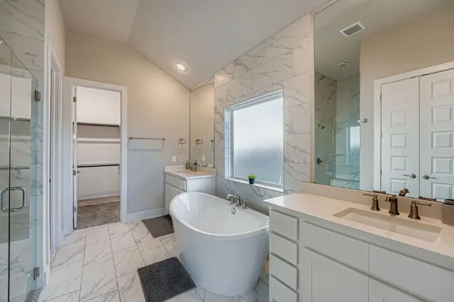 a bathroom with a double vanity sink a mirror and a bathtub