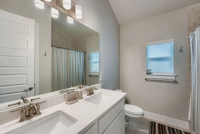 a bathroom with a sink vanity granite and toilet