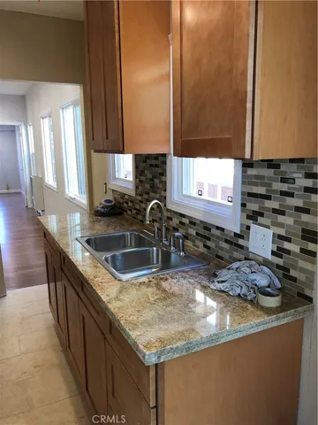 a kitchen with granite countertop a sink and a stove
