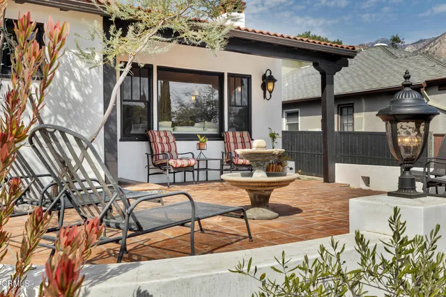 a view of a patio with couches table and chairs with potted plants
