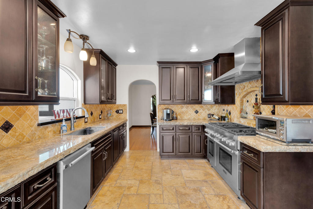 1807 Vistillas Road Altadena, CA 91001 - Photo 12 of 38 a large kitchen with stainless steel appliances granite countertop wooden cabinets a sink dishwasher a stove and a refrigerator