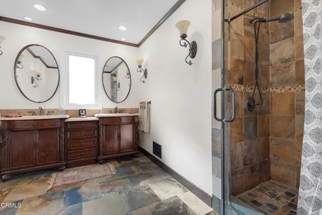 a bathroom with a double vanity sink mirror and shower