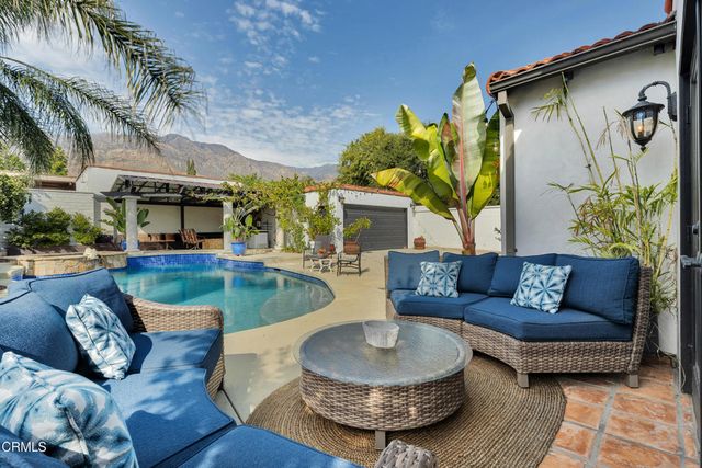 a view of a patio with couches table and chairs and potted plants