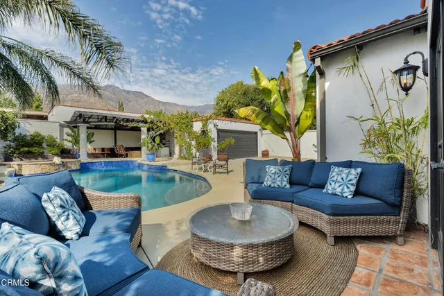 a view of a patio with couches table and chairs and potted plants