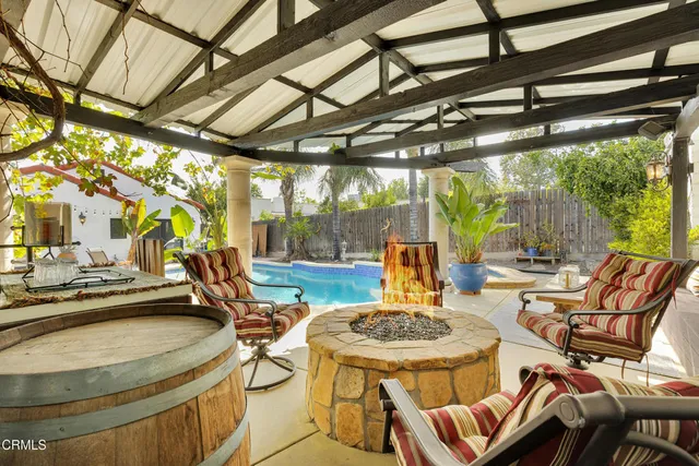a view of a patio with a table chairs and a barbeque