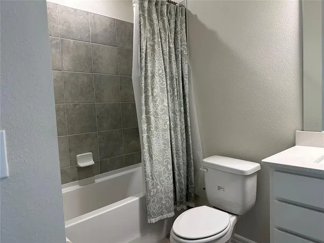 a white toilet sitting next to a bath tub